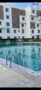 a large swimming pool in front of a building at She-goes apartments in Mombasa