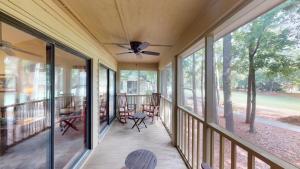 a screened porch with windows and a ceiling fan at Golf Course Charm Pawleys Getaway in Pawleys Island