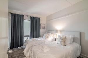 two white beds in a room with a window at Litchfield Retreat near Brookgreen Gardens in Pawleys Island +11 photos