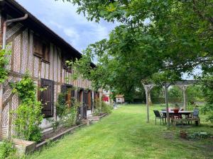 a house with a picnic table in the yard at Le chêne magique 40200 Margaux in Pontenx-les-Forges
