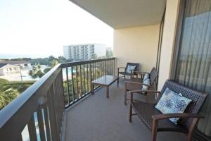 einen Balkon mit Bänken und Stühlen auf einem Gebäude in der Unterkunft 3 Bedroom Beach Condo at Litchfield By the Sea in Pawleys Island