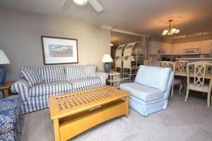 ein Wohnzimmer mit Sofa, Stühlen und einem Tisch in der Unterkunft 3 Bedroom Beach Condo at Litchfield By the Sea in Pawleys Island