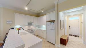 eine Küche mit weißen Schränken und einem weißen Kühlschrank in der Unterkunft Marshview Retreat 3BR with Stunning Marsh Views in Pawleys Island + 15 Fotos