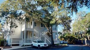ein weißes Auto, das vor einem Haus parkt in der Unterkunft Marshview Retreat 3BR with Stunning Marsh Views in Pawleys Island