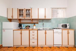 a kitchen with white cabinets and a white refrigerator at Apartments with parking space Fazana - 18334 in Fažana +22 photos