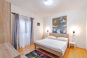 ein Schlafzimmer mit einem Bett und einem Gemälde an der Wand in der Unterkunft Seaside holiday house Brna, Korcula - 19219 in Smokvica