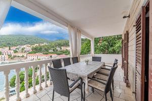 ein Esszimmer mit Tisch und Stühlen auf einem Balkon in der Unterkunft Seaside holiday house Brna, Korcula - 19219 in Smokvica