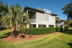a house with a palm tree in front of it at A 4 Bedroom House in Gated Litchfield By the Sea in Pawleys Island
