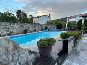 a swimming pool in a yard with a stone wall at A casa da charca in Valga