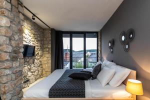 a bedroom with a bed and a stone wall at Family friendly house with a swimming pool Dolinci, Crikvenica - 23065 in Grižane