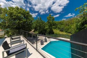 a view from the balcony of a house with a swimming pool at Family friendly house with a swimming pool Dolinci, Crikvenica - 23065 in Grižane
