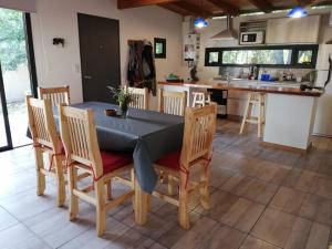 a dining room with a table and chairs and a kitchen at Cabaña Coyam in Villa del Dique