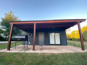 a shed with a grill in front of a house at Cabaña Coyam in Villa del Dique