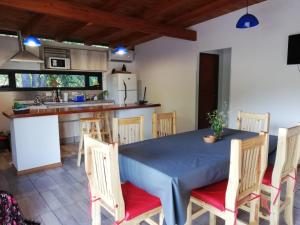 a kitchen and dining room with a blue table and chairs at Cabaña Coyam in Villa del Dique