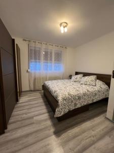 una camera da letto con un letto e una finestra di Maison 8 personnes a Faches-Thumesnil