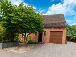 ein Backsteinhaus mit einer Garage und einem Baum in der Unterkunft Magnificent home in Tilf with garden in Tilff