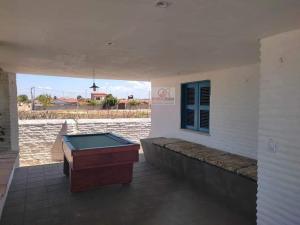 a pool table on a patio with a view of the water at Linda casa Taiba in São Gonçalo do Amarante