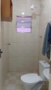 a bathroom with a white toilet and a sink at Apartamento aconchegante em Santana de Parnaíba SP in Santana de Parnaíba +1 photo