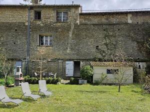 un gruppo di sedie seduti di fronte a un edificio di Gîte tout inclus avec jardin privatif, proche centre Richelieu et châteaux de la Loire - FR-1-381-565 a Richelieu
