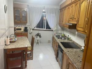 Una cocina con gabinetes de madera y encimera. en Apartamento Xaquina, en Melide 10 fotos más
