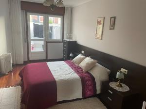 un dormitorio con una cama y una ventana en Apartamento Xaquina, en Melide