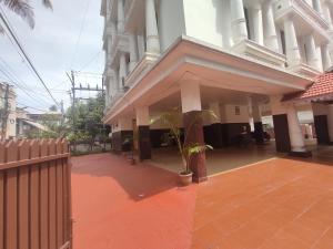 a building with a porch with a plant in it at Orient Glory - Walk to Lulumall & Metro in Edappally