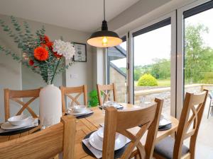 a dining room with a table and chairs and a window at Ty Gambo in Matlock