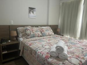 a bedroom with a bed with towels on it at Aconchegante Flat Premiere Rio Centro in Rio de Janeiro