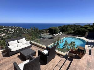 eine Terrasse mit einem Sofa und Stühlen neben einem Pool in der Unterkunft Villa climatisée 4 chambres avec piscine privée, wifi et animaux admis - FR-1-768-91 in Saint-Peïre-sur-Mer