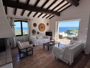 ein Wohnzimmer mit weißen Möbeln und Blick auf das Meer in der Unterkunft Villa climatisée 4 chambres avec piscine privée, wifi et animaux admis - FR-1-768-91 in Saint-Peïre-sur-Mer