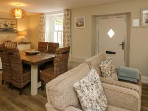 ein Wohnzimmer mit Sofa und Tisch in der Unterkunft Pheasant Cottage in Ilfracombe