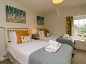 ein Schlafzimmer mit zwei Betten und einem Fenster in der Unterkunft Pheasant Cottage in Ilfracombe