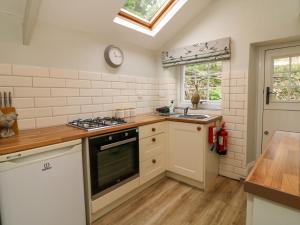 une cuisine avec un évier et une cuisinière four supérieur dans l'établissement Partridge Cottage, à Ilfracombe 21 autres photos