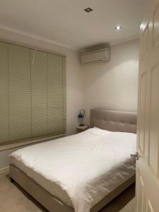 une chambre avec un lit blanc et une fenêtre dans l'établissement Hunter house, à Camberwell