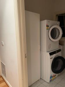 un micro-ondes et une machine à laver dans une chambre dans l'établissement Hunter house, à Camberwell