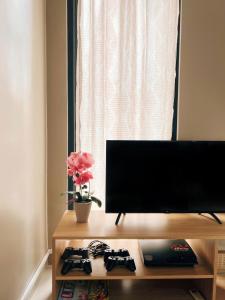 ein Flachbildfernseher auf einem Tisch neben einem Fenster in der Unterkunft AZ Villa Batu M14 - Fullhouse 3 Bedroom in Tlekung