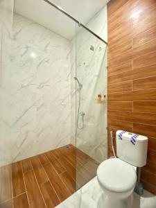 ein Badezimmer mit Toilette und Glasdusche in der Unterkunft AZ Villa Batu M14 - Fullhouse 3 Bedroom in Tlekung + 11 Fotos