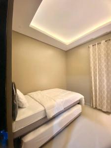 ein Schlafzimmer mit einem Bett und einem Fenster in der Unterkunft AZ Villa Batu M14 - Fullhouse 3 Bedroom in Tlekung