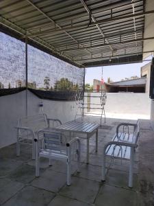 a patio with a table and two chairs under a roof at Maileyna Homestay 2 in Kampong Alor Merah +8 photos