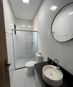 a bathroom with a toilet and a sink and a mirror at AP 15 - 500m da BEIRA MAR de Taperapuan, 2 quartos in Porto Seguro
