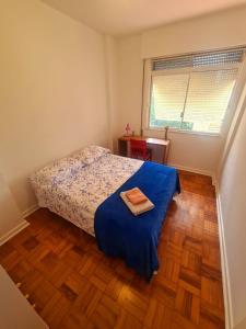 una piccola camera da letto con un letto con un lenzuolo blu di Quarto, bairro Bela Vista, próximo a Avenida Paulista a San Paolo