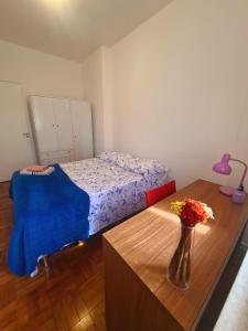 una camera da letto con un letto e un tavolo con un vaso di fiori di Quarto, bairro Bela Vista, próximo a Avenida Paulista a San Paolo