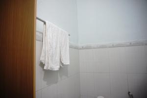 toalla blanca colgada en la pared del baño en Thảo Nguyên MoTel, en A Sơ Ră Amo
