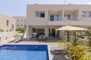 a villa with a swimming pool and a house at Protaras Mythical Seas in Protaras