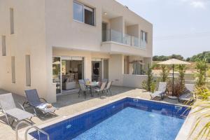 a villa with a swimming pool and a house at Protaras Mythical Seas in Protaras