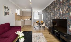 un salon avec un canapé violet et une table dans l'établissement NiMFa THE BEST - EXLUSIVE 10, à Kudowa-Zdrój