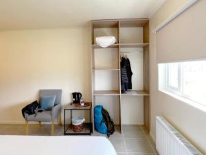 a room with a bed and a chair and shelves at Hotel Casa Verde in Puerto Natales