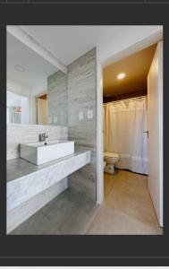 Un baño con un lavabo blanco y un inodoro. en Torres al Mar, en Monte Hermoso