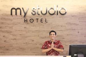 a man standing in front of a hotel sign at My Studio Hotel Losari Makassar in Makassar