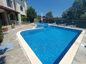a swimming pool with blue water in a yard at Oasis beach house , apartment Nevena in Lozenets